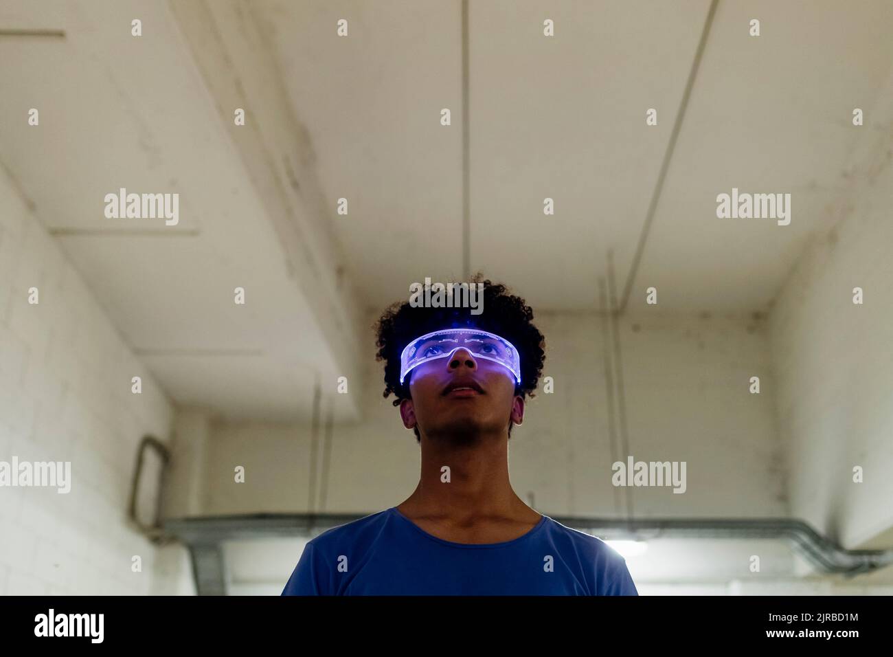 Jeune homme portant des lunettes métaverse dans un passage souterrain Banque D'Images