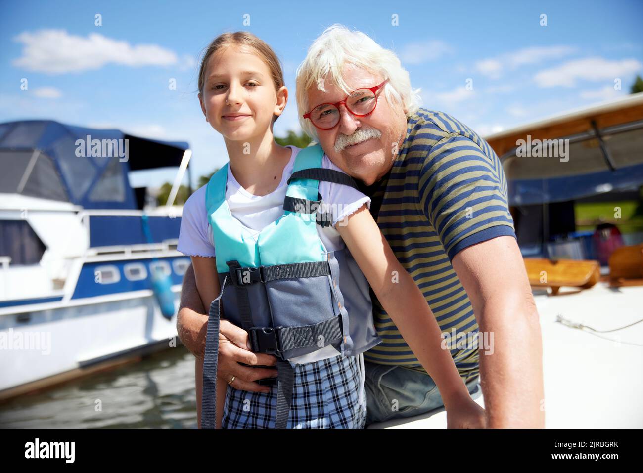 Grand pere embrassant la petite fille portant un gilet de sauvetage sur le bateau Photo Stock Alamy