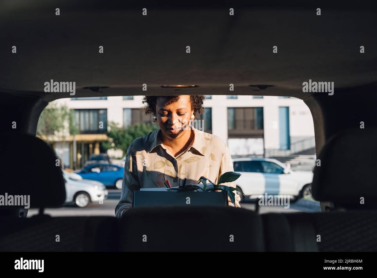 Femme d'affaires tenant la boîte dans le coffre de voiture Banque D'Images