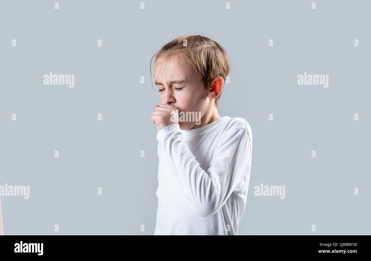 Le petit garçon tousse, sur fond gris. Garçon toussant mal rhumes éternuant toux. L'enfant est tombé malade avec un virus. Les enfants toughs. L'enfant est malade, lui Banque D'Images