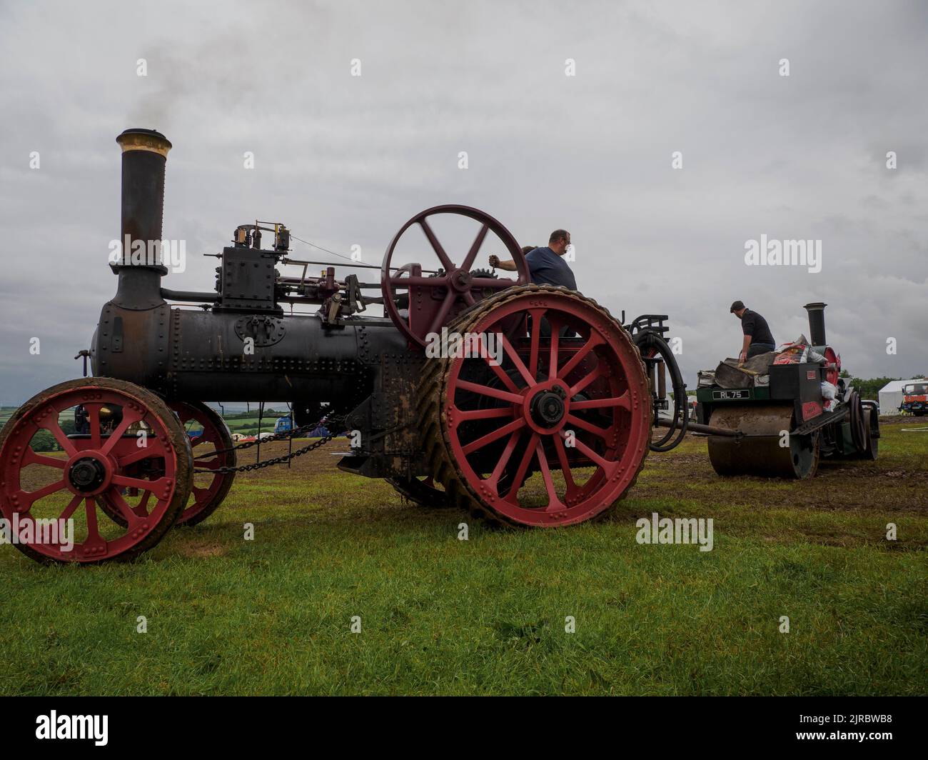 Moteur de traction remorquant un rouleau à vapeur hors de la boue au Launceston Steam & Vintage Rally, Cornwall, Royaume-Uni Banque D'Images