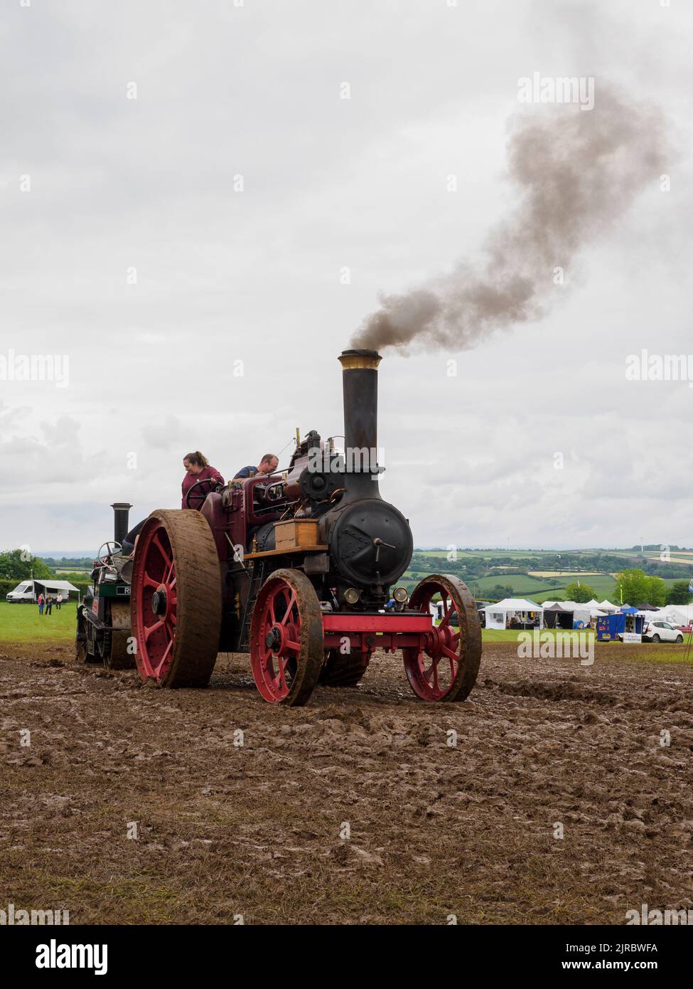 Moteur de traction remorquant un rouleau à vapeur hors de la boue au Launceston Steam & Vintage Rally, Cornwall, Royaume-Uni Banque D'Images