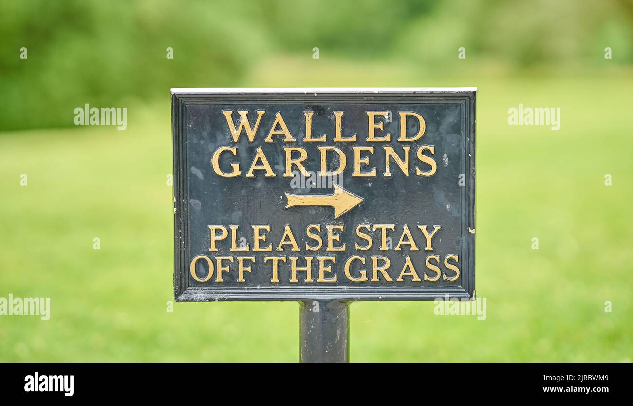 Un panneau d'information demandant poliment aux gens de rester hors de l'herbe. Banque D'Images