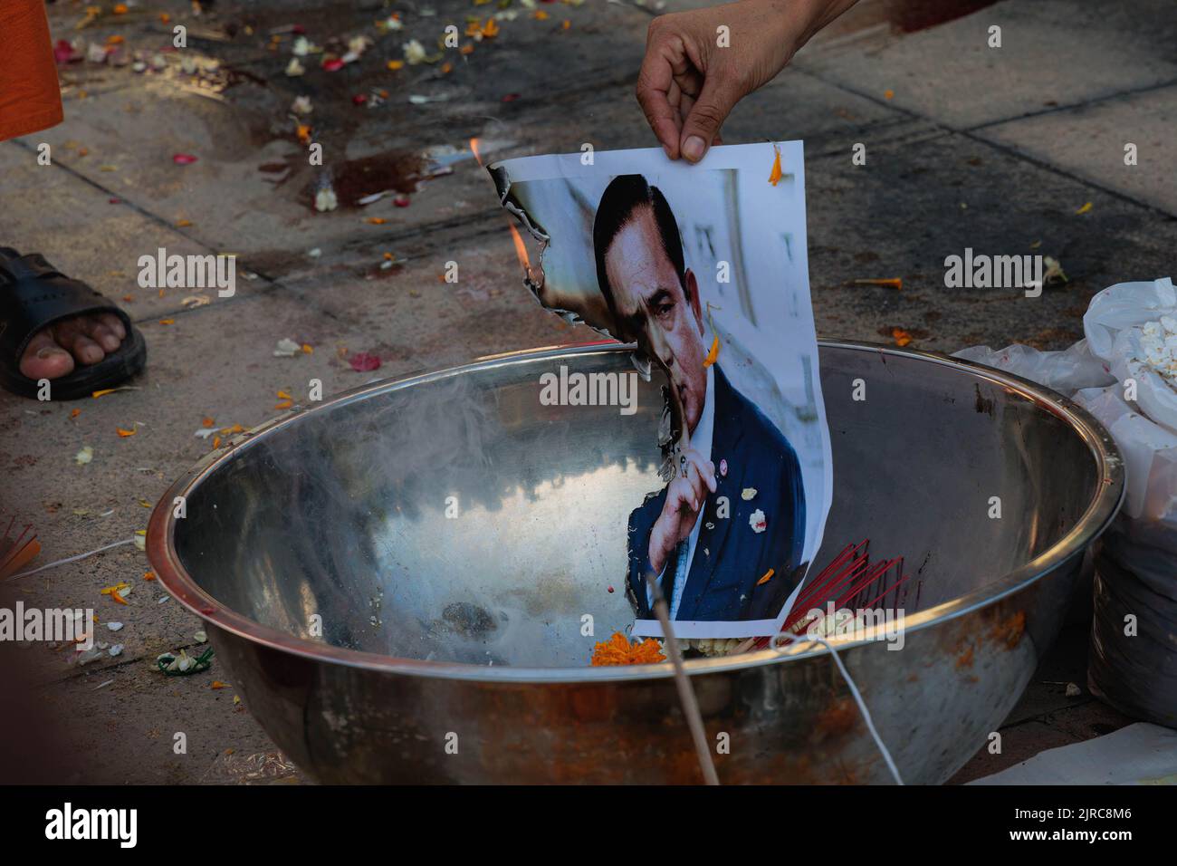 Bangkok, Thaïlande. 23rd août 2022. Un manifestant brûle un portrait de Prayut Chan-ocha avec du sel et du Chili pour faire une malédiction culturelle thaïlandaise lors d'une manifestation devant le monument de la démocratie. Les manifestants pro-démocratie protestent contre le Premier ministre thaïlandais, Prayut Chan-ocha, qui demande sa démission et disent que Prayut Chan-ocha a dépassé la limite de son mandat par la constitution. Crédit : SOPA Images Limited/Alamy Live News Banque D'Images