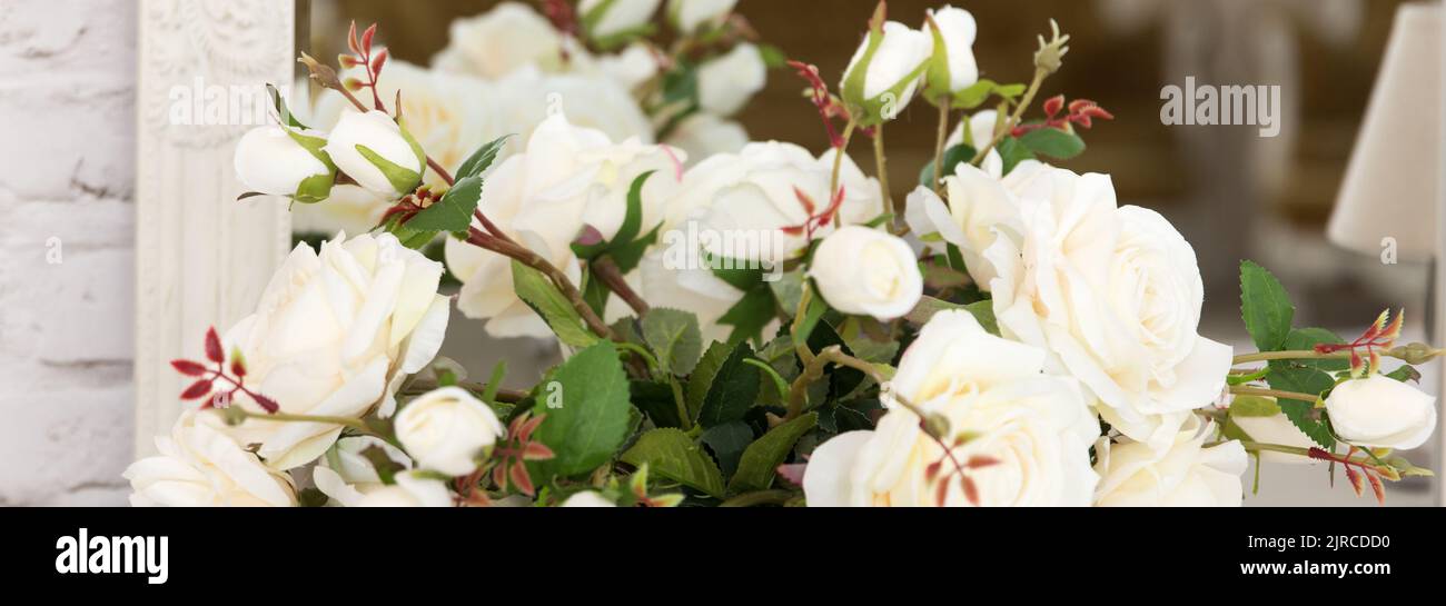 Bouquet de roses ornementales blanches en matériau et en plastique se trouve sur la table comme partie de l'intérieur Banque D'Images