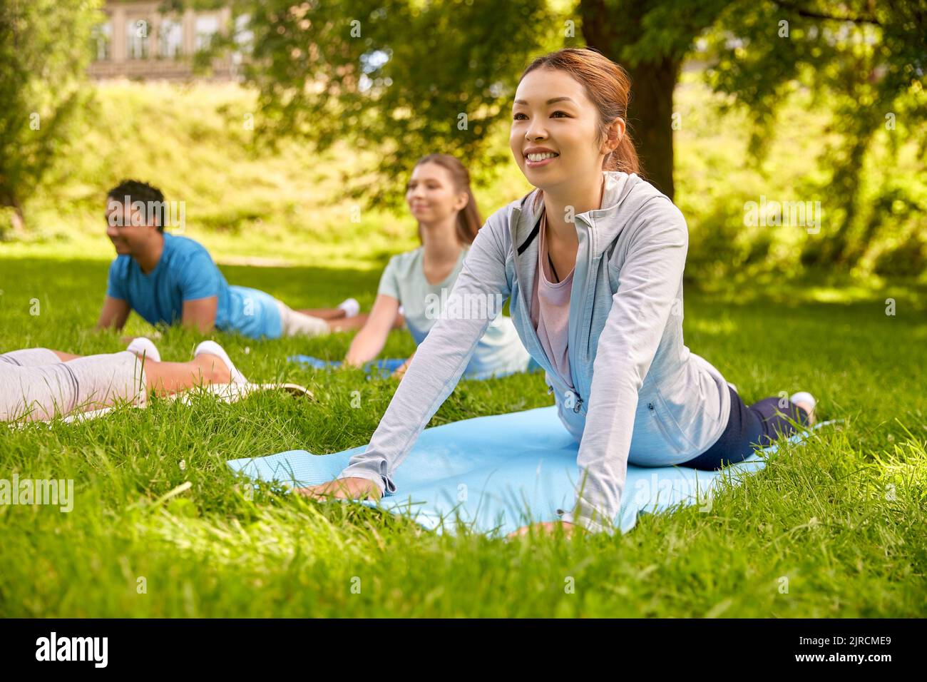 groupe de personnes faisant du yoga au parc d'été Banque D'Images