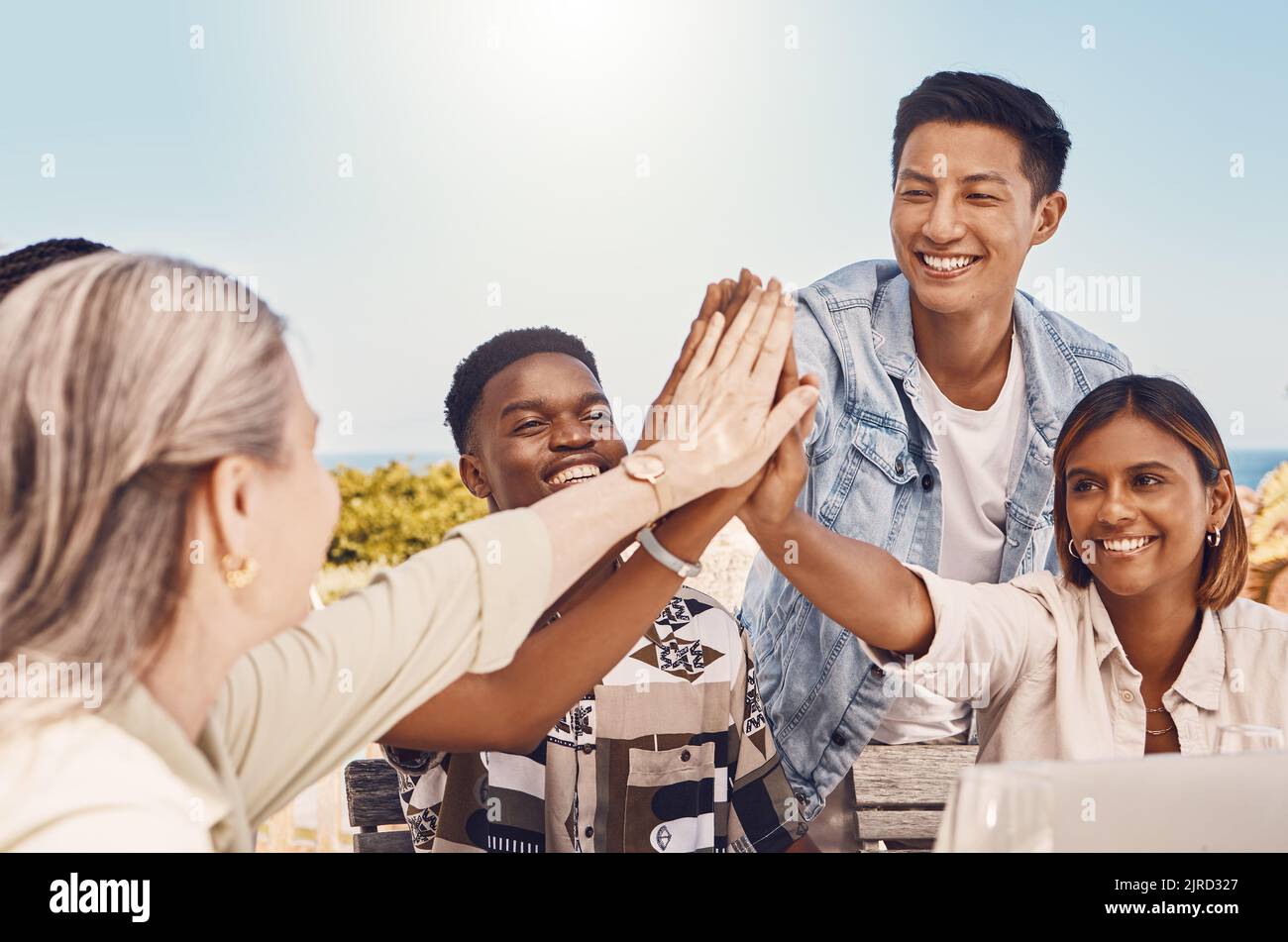 Confiance, communauté et collaboration avec les cinq personnes les plus importantes par des collègues de travail qui apprécient le travail d'équipe et qui s'amusent ensemble en plein air. Un groupe diversifié rejoint l'objectif Banque D'Images