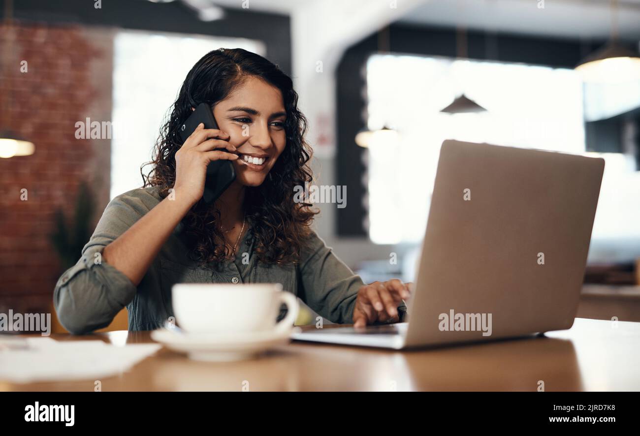 Freelance, entrepreneur ou propriétaire de petite entreprise parlant, en réseau et prévoit sur un appel téléphonique tout en lisant des e-mails sur un ordinateur portable. Travailleur à distance féminin Banque D'Images