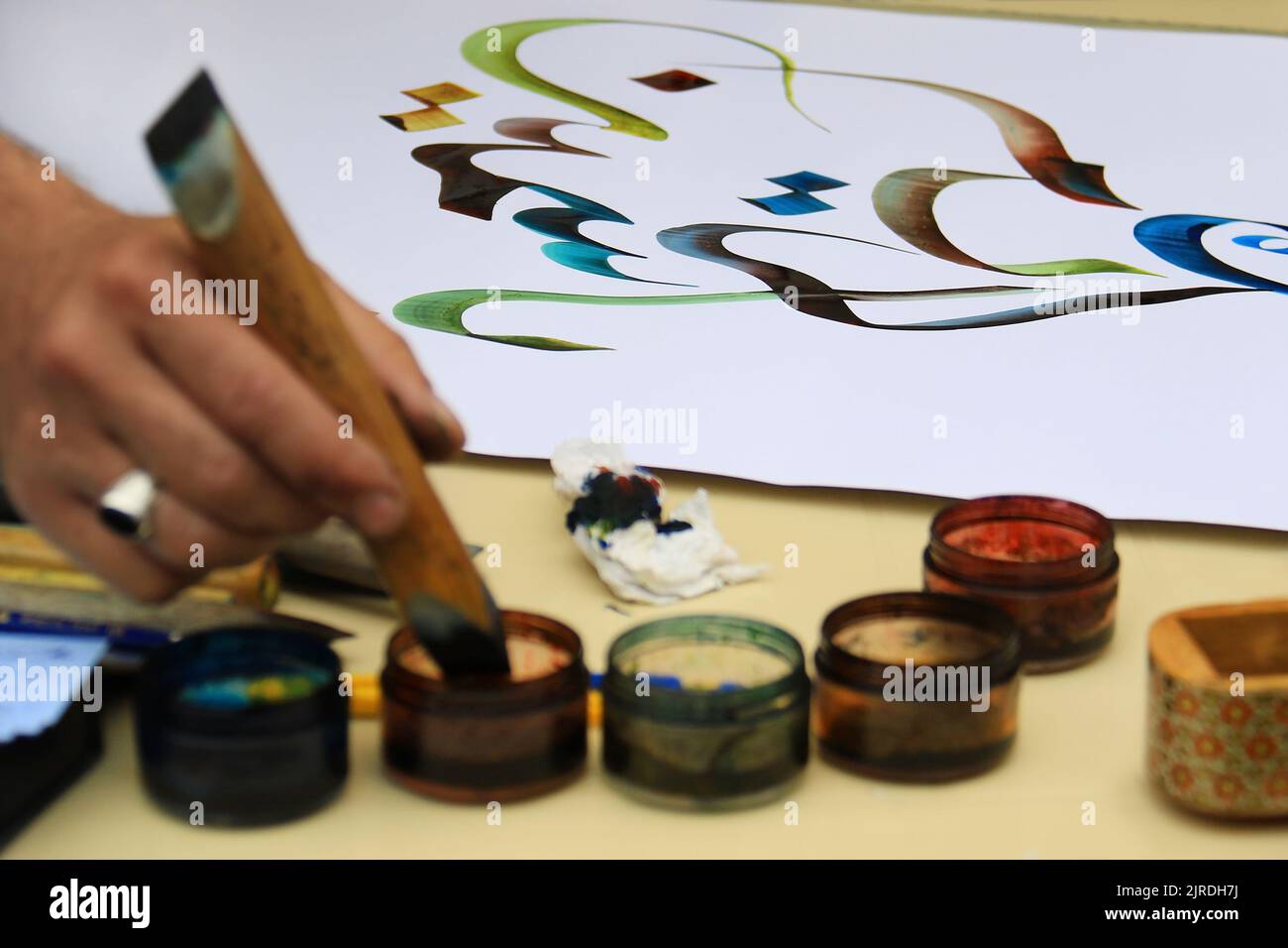Un artiste de calligraphie et ses écrits arabes. Banque D'Images