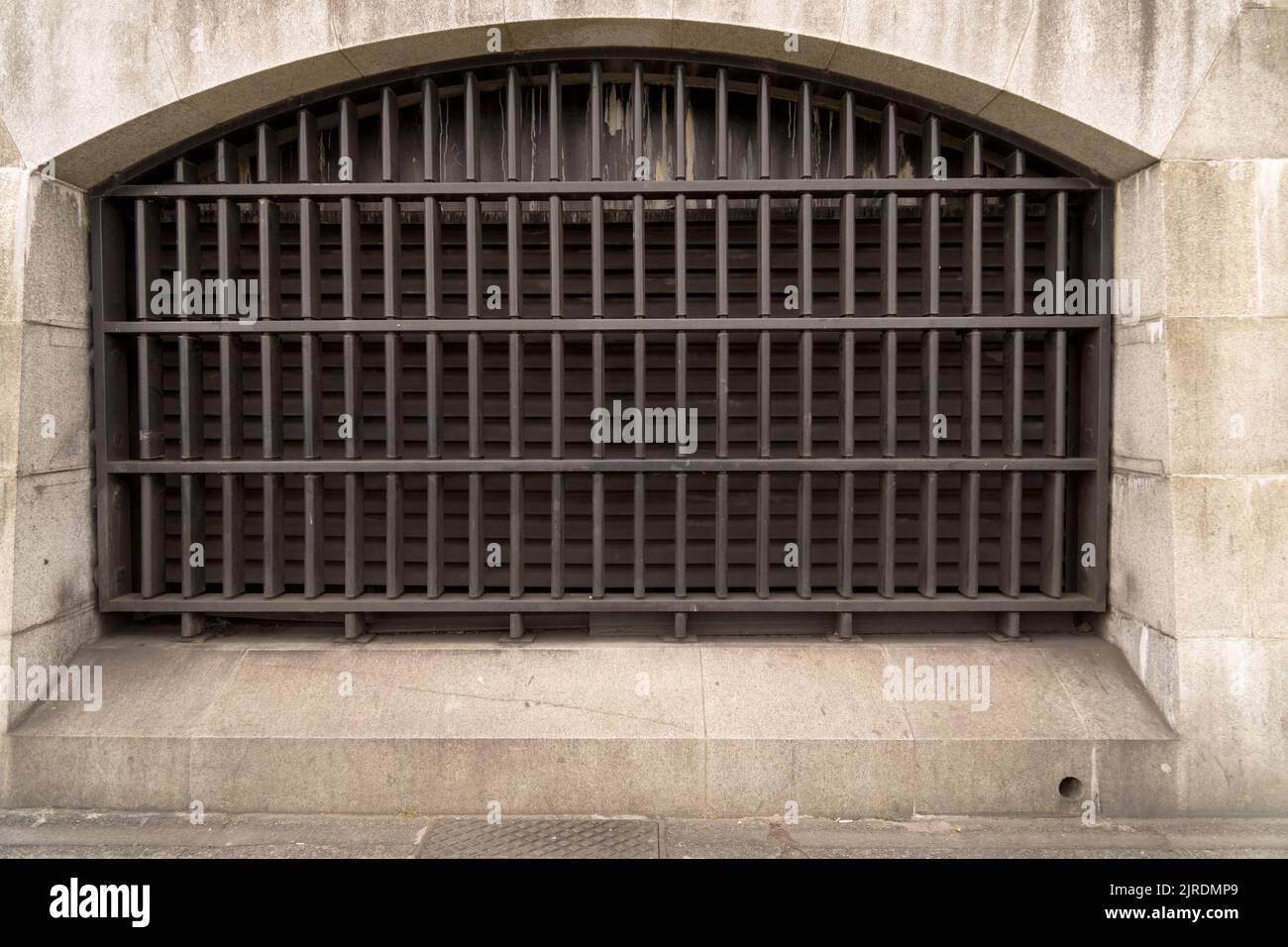 Gros plan de la fenêtre fortement barrée de treillis métallique solide dans l'ancien bâtiment historique comme concept de prison et de protection contre les cambriolages Banque D'Images