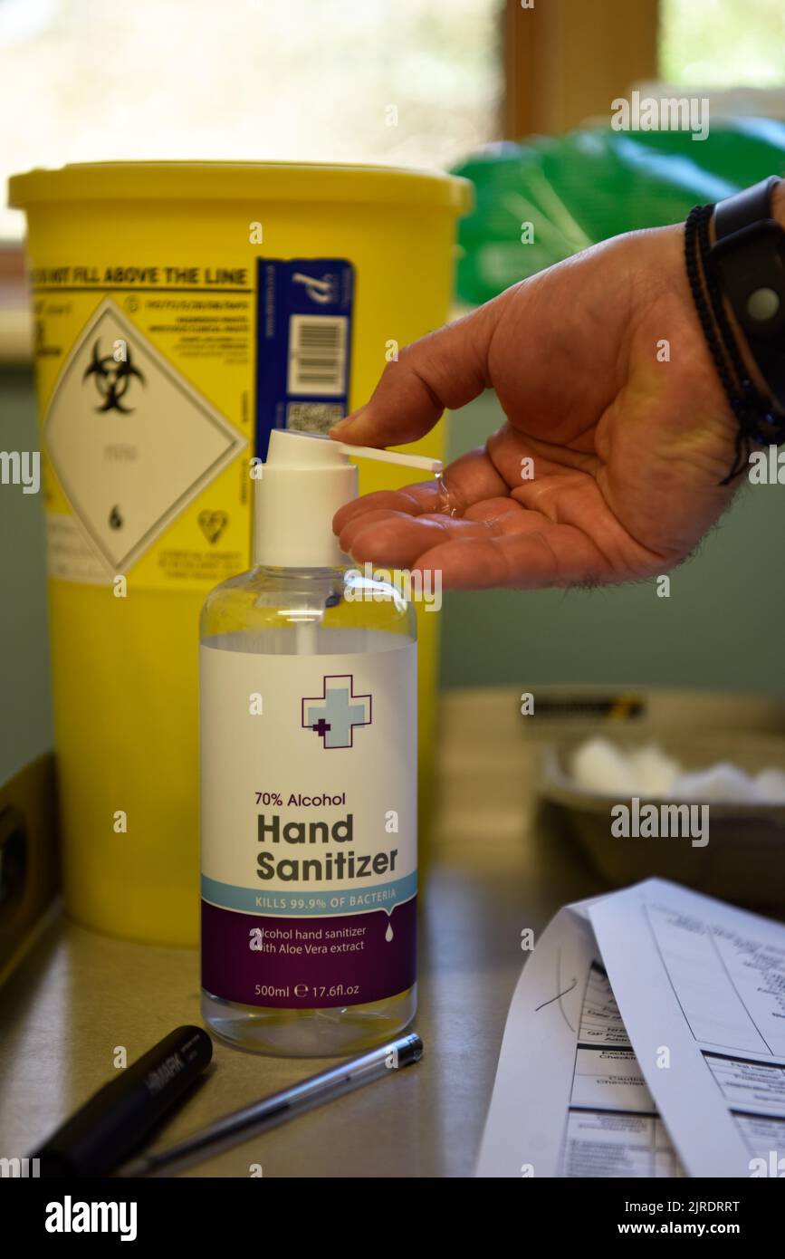 Membre de l'équipe médicale utilisant un désinfectant pour les mains pendant le déploiement du vaccin COVID-19, Bordon, Hampshire, Royaume-Uni. Banque D'Images