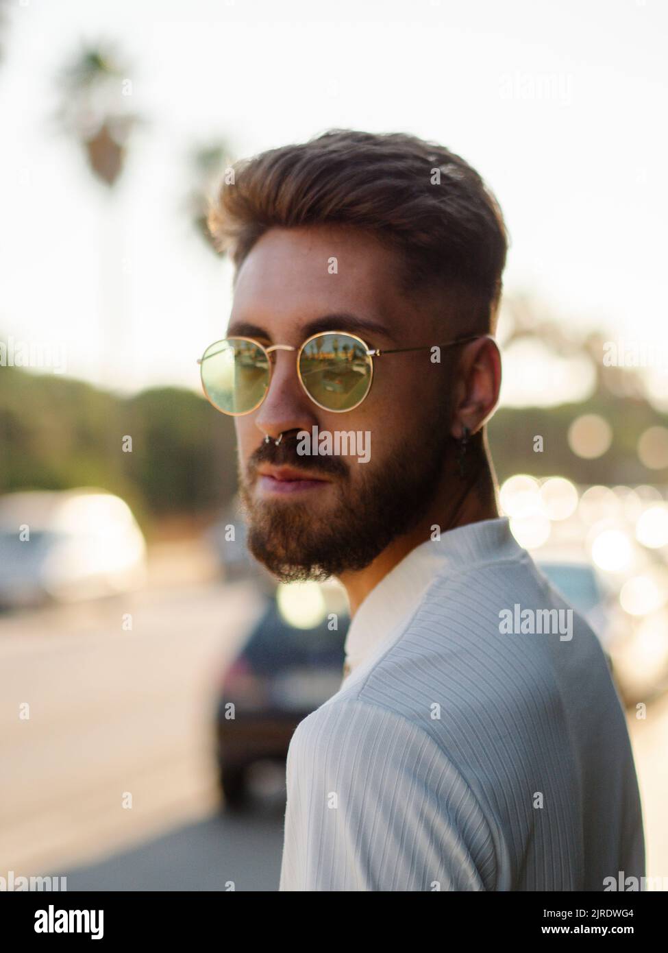 Un jeune homme élégant espagnol avec une coiffure élégante, des tatouages,  et des lunettes de soleil Photo Stock - Alamy
