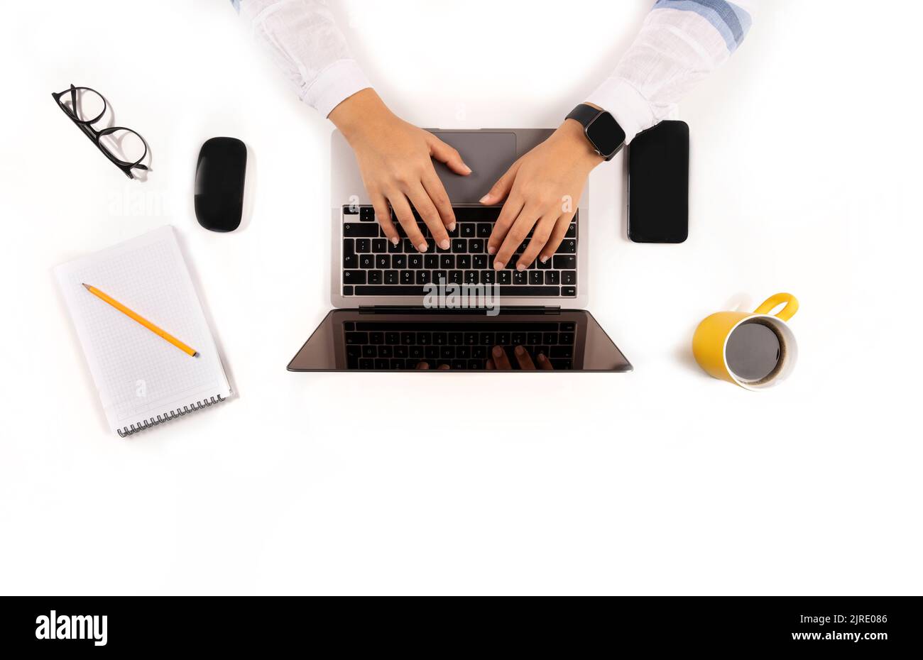 Travaillant sur un ordinateur portable moderne, les femmes caucasiennes travaillant sur un ordinateur portable moderne. Vue de dessus de la table blanche de bureau elle a ses lunettes, souris noire. Banque D'Images