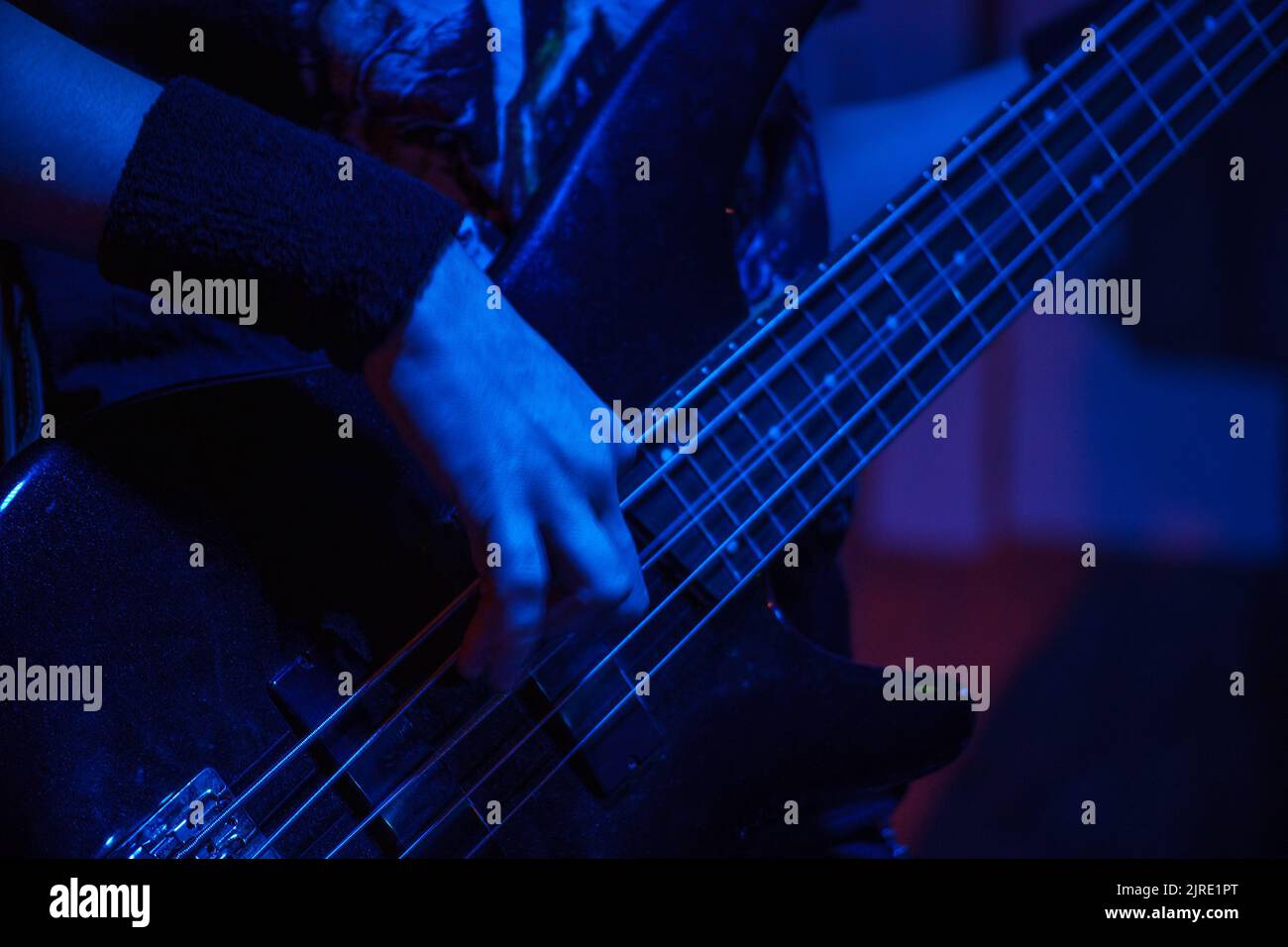 Le guitariste joue la guitare basse. Touche sombre. Mise au point sélective Banque D'Images