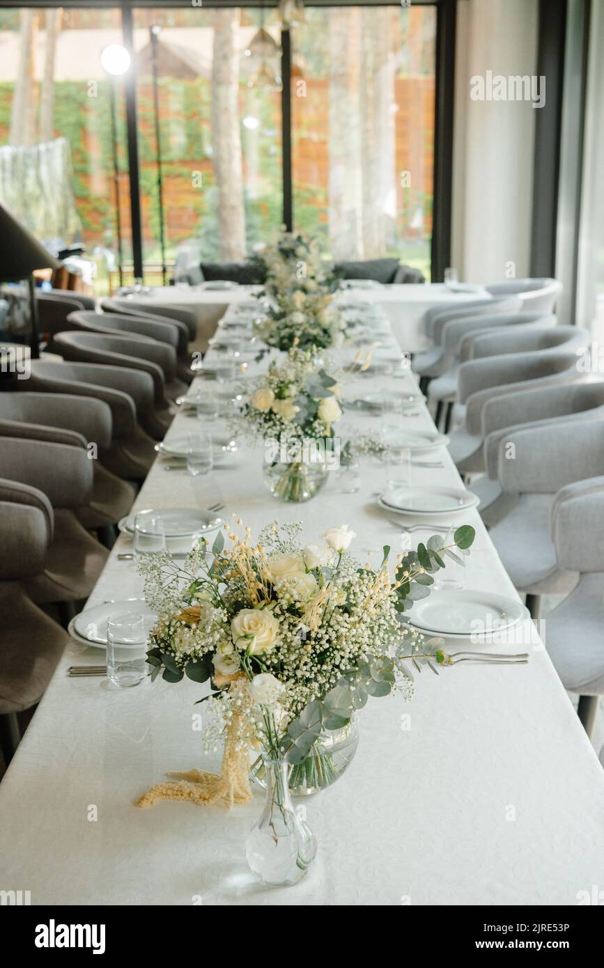 Table de réception de mariage dans le restaurant décoré de bougies blanches et de fleurs. Banque D'Images