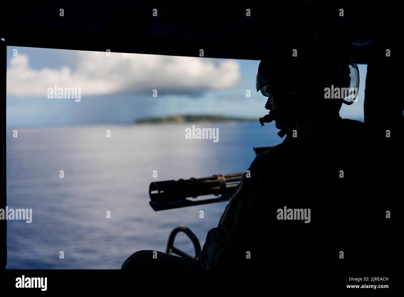 Caporal du corps des Marines des États-Unis Josh Flaller, chef d'équipage du Marine Light Attack Helicopter Squadron (HMLA) 469, balaye l'horizon au large de la côte d'Okinawa, au Japon, le 3 août 2022. La MLA-469 a mené un exercice de coordination et de reconnaissance des grèves afin d'accroître la compétence et la létalité dans l'ensemble de l'escadron. (É.-U. Photo du corps marin par PFC. Justin J. Marty) Banque D'Images