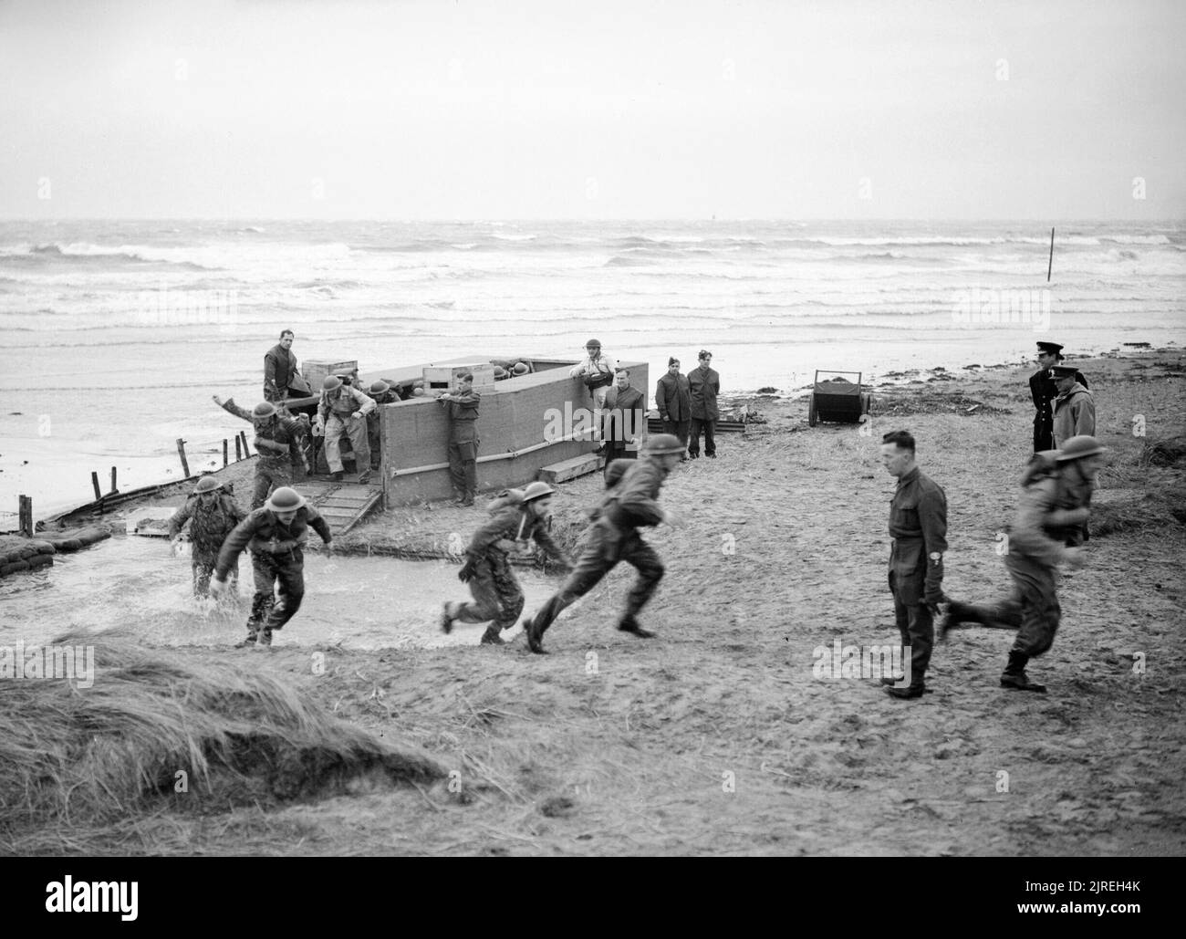 La Royal Navy pendant la Seconde Guerre mondiale, Lord Louis Mountbatten (à droite) de regarder un exercice d'atterrissage sur la plage, à l'opérations combinées centre à Camp. Dundonald Remarque Le fait que les hommes sont à l'aide d'un mannequin de débarquement, la rampe qui mène à de fosse peu profonde remplie d'eau afin de simuler un vrai débarquement amphibie. Banque D'Images