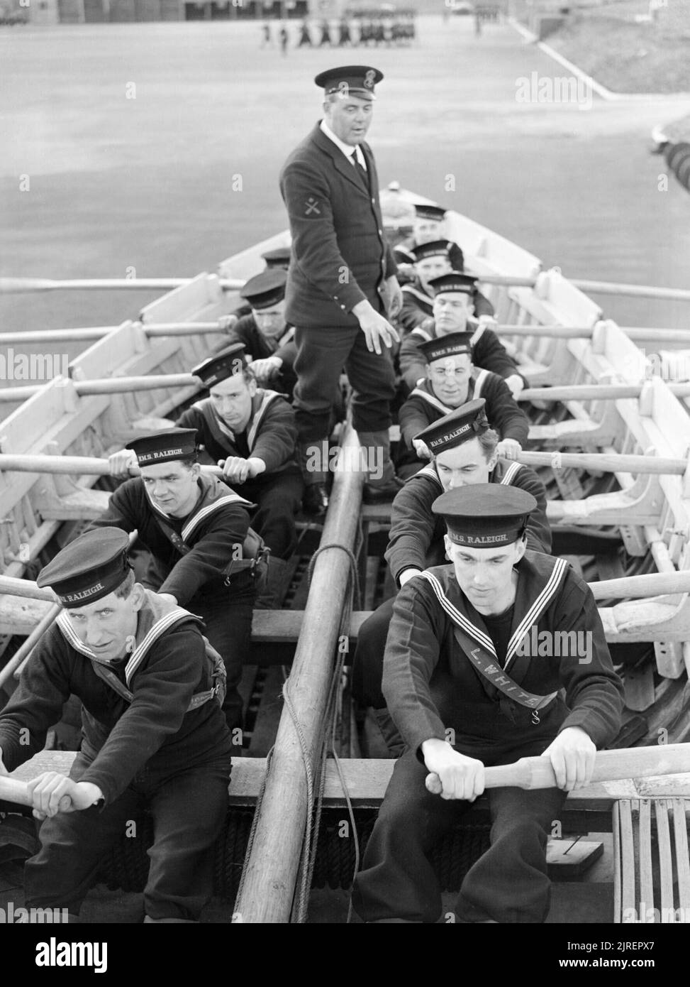 Les recrues de la marine apprendre à ramer un bateau à HMS RALEIGH, la base d'entraînement naval à Torpoint à Cornwall, en 1941. À HMS RALEIGH, la base d'entraînement naval à Torpoint, Cornwall, de nouvelles recrues à la Marine apprendre à tirer (ligne) un bateau sur la terre ferme, à l'instruction préparatoire sur l'eau à proximité. Cette photographie est tirée d'une série d'images en suivant les progrès d'un homme (John Smith) joindre la marine royale et par la formation. Banque D'Images