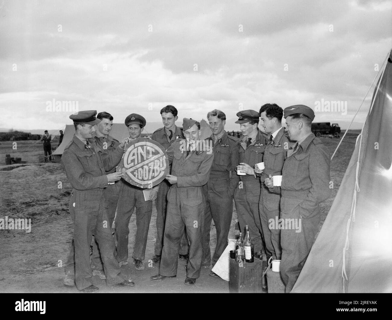 Opérations de la Royal Air Force au Moyen-Orient et en Afrique du Nord, 1939-1943. Le Lieutenant d'D H Greaves (extrême gauche) et l'Adjudant F M Robbins (cinquième à partir de la gauche), la réussite d'un Bristol Beaufighter avec l'équipe de combat de nuit n° 255 Squadron RAF, afficher un trophée coupé de leur cinquième victime, un Cant Z1007 qu'ils ont intercepté plus de Bone dans la nuit du 18/19 janvier 1943, à d'autres membres de l'escadron à Sétif, Algérie. Le groupe comprend 255's commandant, Commandant de l'Escadre D P D G Kelly, l'article deuxième de la droite. Greaves (pilote) et Robbins (opérateur radar) ont joint leurs forces tout en Banque D'Images