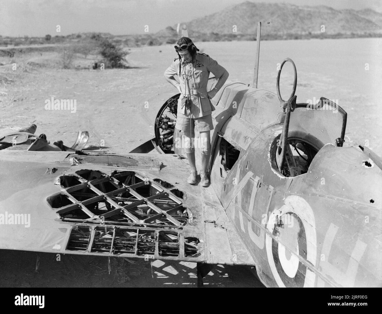 Royal Air Force- Afrique de l'Est, 1940-1945. Officier pilote de Kennedy n° 47 Squadron RAF inspecte le détachement de dommages à son Vickers Wellesley, K7715 "KU-H', à Agordat, Érythrée, après qu'il a été attaqué par deux Fiat CR 42s lors d'un attentat à la sortie sur le Keren le 25 mars 1941. Son mitrailleur, le sergent allemand, a été mortellement blessé et l'aile gauche a été incendiée. Kennedy a effectué une plongée verticale d'éteindre les flammes et est retourné à la base du détachement à Agordat, où il s'est écrasé à l'atterrissage. Banque D'Images