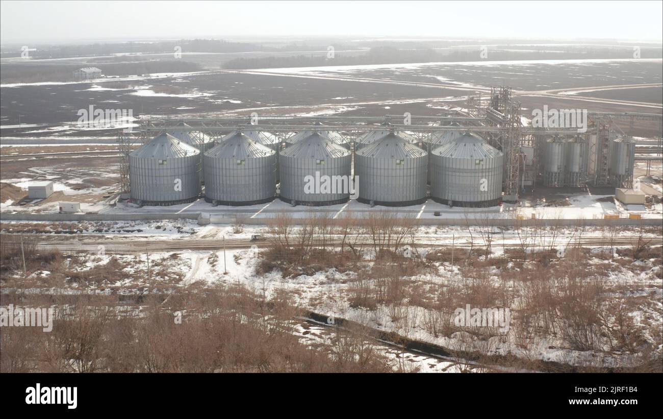 Élévateur de stockage de grain. Paysage d'hiver en soirée. Ascenseur industriel sur le fond d'un champ d'hiver. Banque D'Images