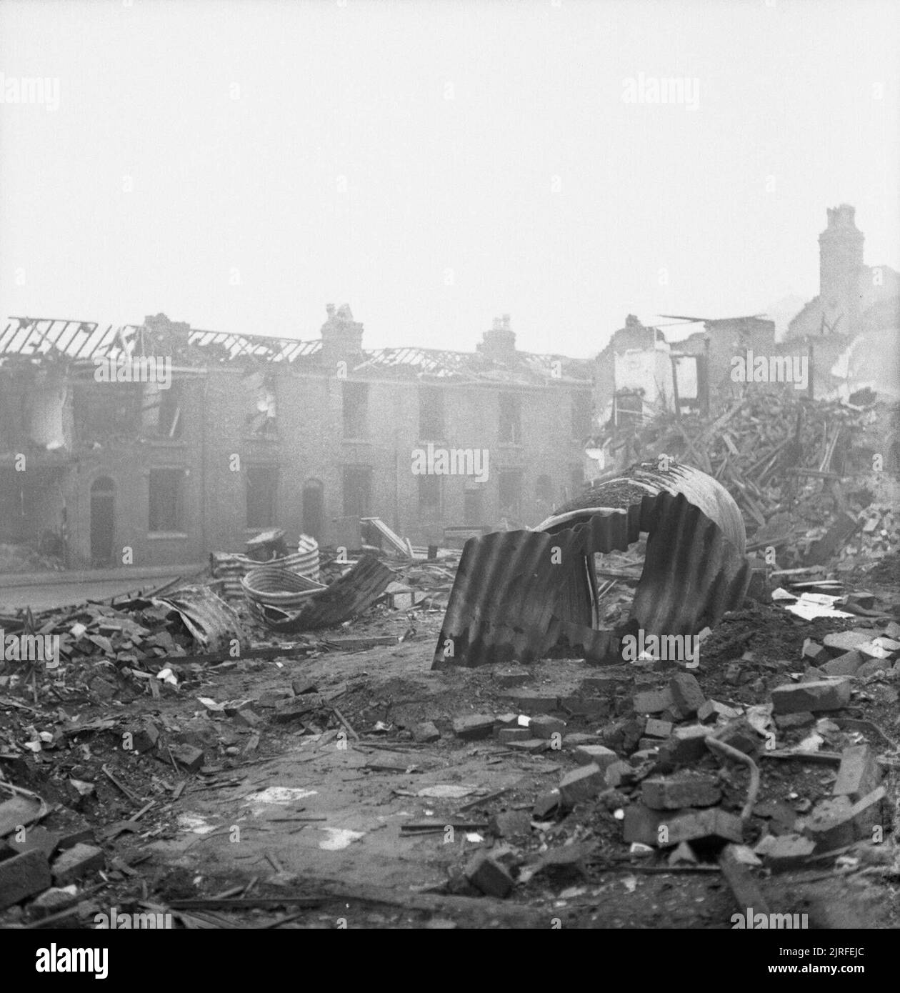 Dommages sur la rue James Bomd, Aston Newtown, Birmingham, 1940. Bien que certains débris ont été effacées sur le site de la rue James, Aston Newtown, Birmingham, gravats brique peut être clairement vu. Dominant la photographie, cependant, sont les vestiges de plusieurs abris Anderson, dont l'un est toujours debout et intact, bien que voilé. Dans le fond, toutes les maisons en rangée de maisons mitoyennes est manquant un toit. Banque D'Images