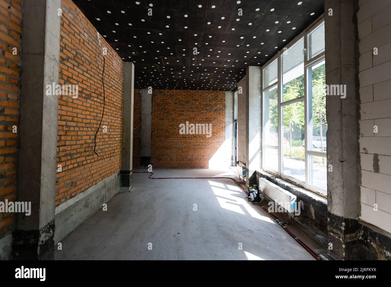 Grande chambre spacieuse, éclairée par la lumière naturelle des fenêtres, espace intérieur vide Banque D'Images
