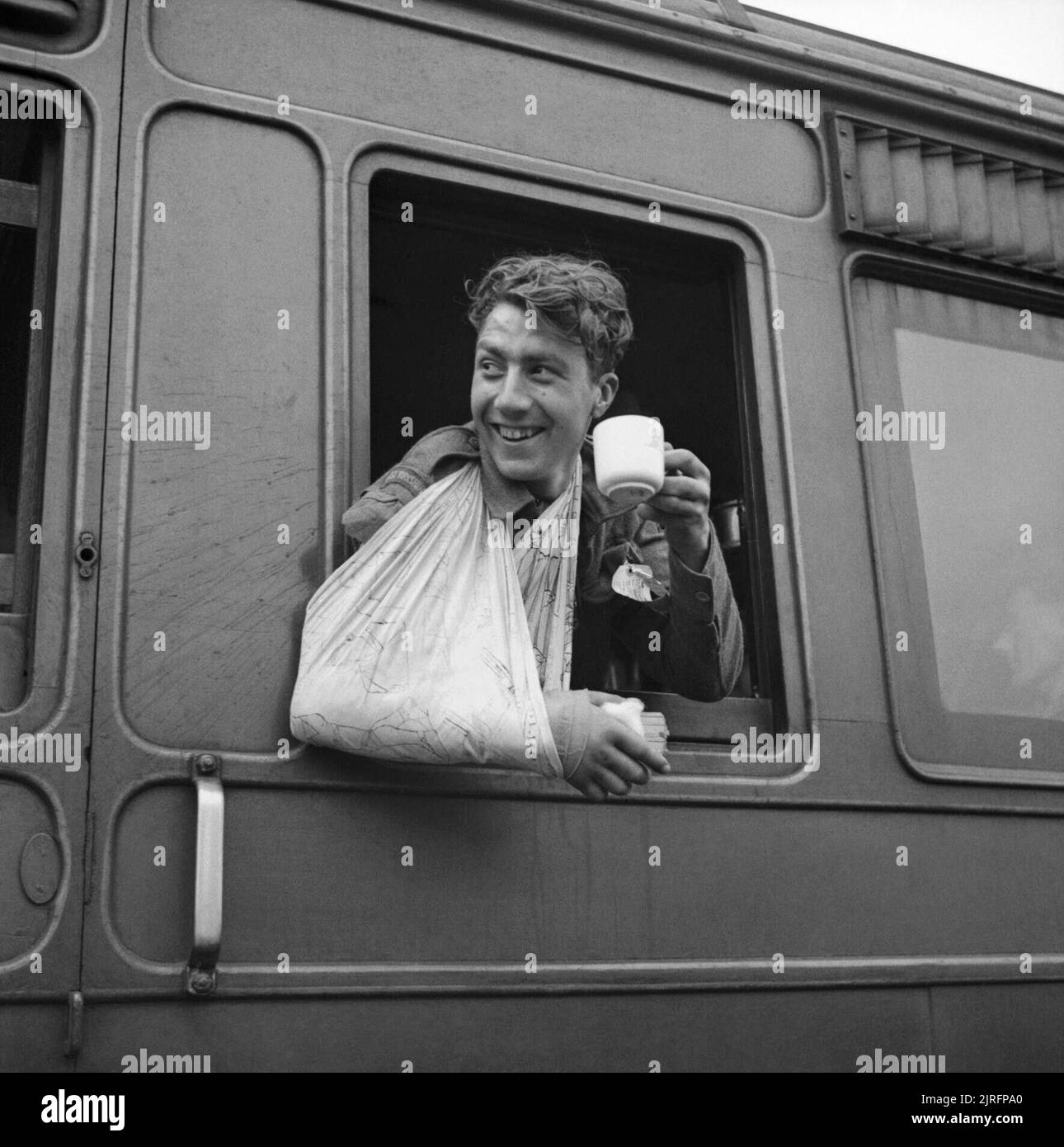 Un soldat blessé, évacué de Normandie, bénéficie d'une tasse de thé sur un train de l'hôpital, 7 juin 1944. Un soldat blessé, évacué de Normandie, bénéficie d'une tasse de thé sur un train de l'hôpital, 7 juin 1944. Banque D'Images