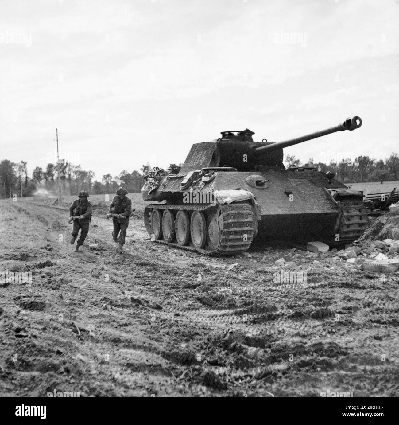 L'Armée britannique en Normandie 1944 hommes de la Durham Light Infantry, 49e Division (West Riding) 'avance' passé un frappé-out Panther allemand au cours de l'opération Epsom 'réservoir', 27 juin 1944. Banque D'Images
