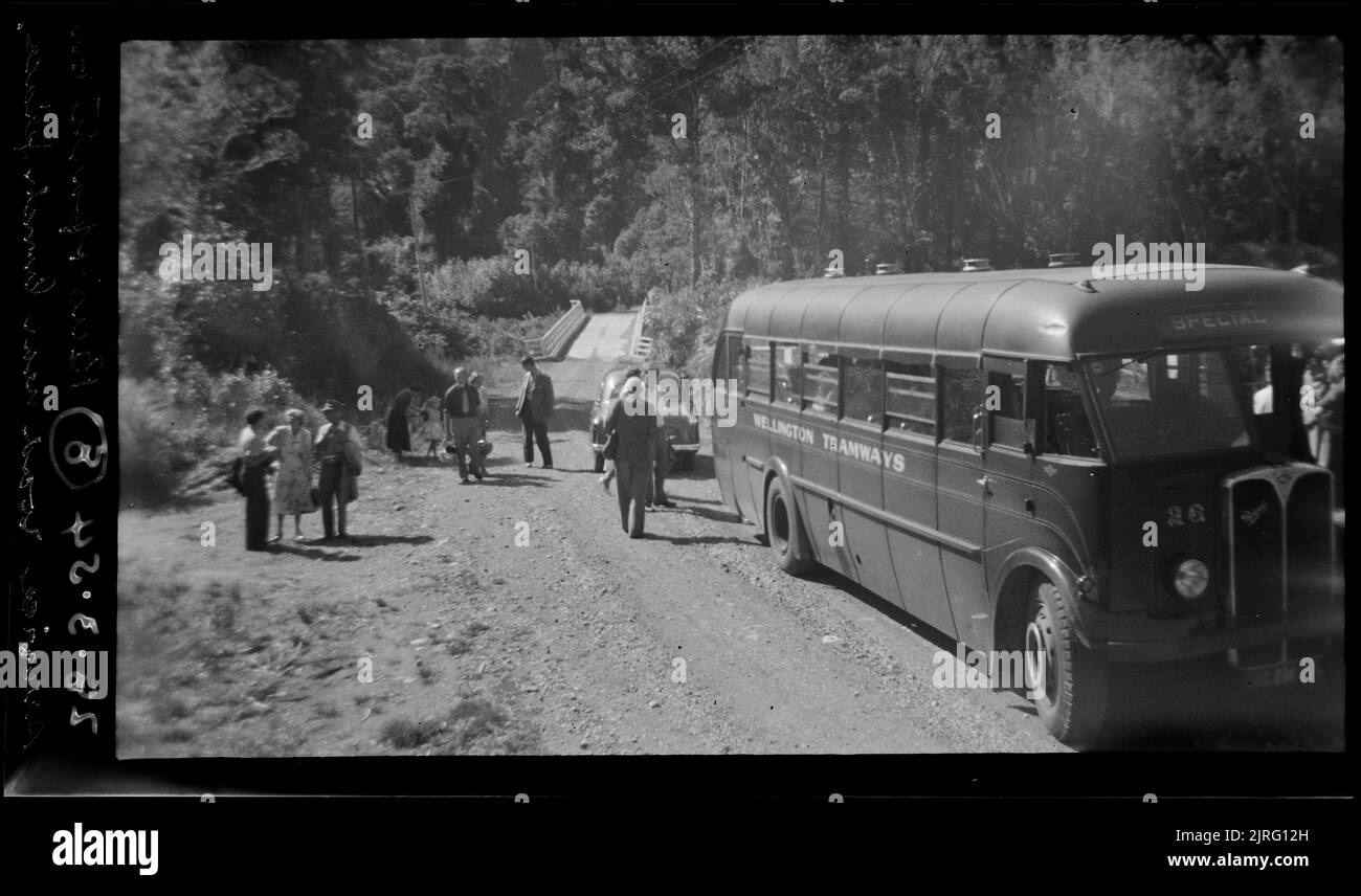 Bus et fête sur la voie de service près de Lunch place (Pakuratahu), 28 mars 1954, par Leslie Adkin. Banque D'Images