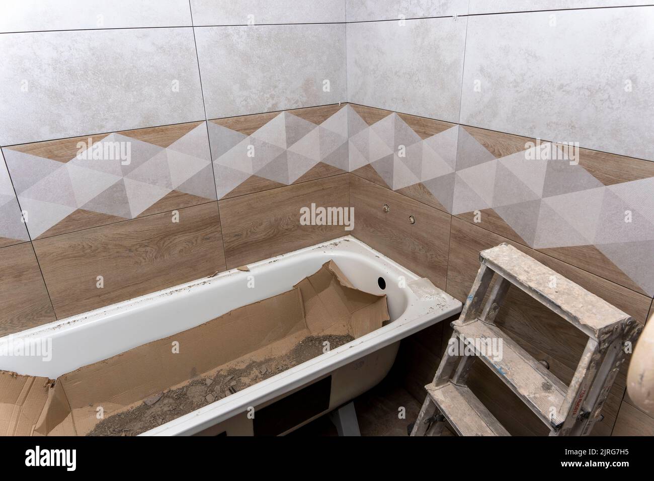 installation d'une nouvelle baignoire et pose de carreaux de céramique dans la salle de bains. Réparer Banque D'Images