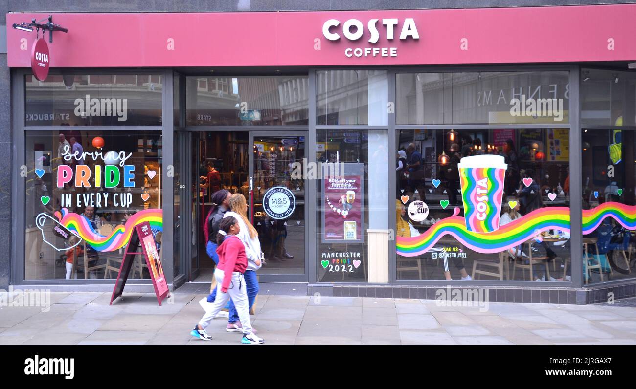 Manchester, Royaume-Uni. 24th août 2022. Les gens marchent devant une image de fierté sur la fenêtre du café Costa. Les entreprises et les agences décorent leurs fenêtres et façades pour accueillir et célébrer la fierté LGBTQ+, Manchester, Royaume-Uni. Le Manchester LGBTQ+ Pride a lieu pendant le week-end des fêtes de banque du 26th au 29th août. Les organisateurs disent: 'Manchester Pride est l'une des principales associations caritatives LGBTQ+ au Royaume-Uni. Notre vision est un monde où les personnes LGBTQ+ sont libres de vivre et d'aimer sans préjudice. Nous faisons partie d'un mouvement fierté mondial qui célèbre l'égalité des LGBTQ+ et qui conteste la discrimination. Crédit : Terry Waller/Alay Live News Banque D'Images
