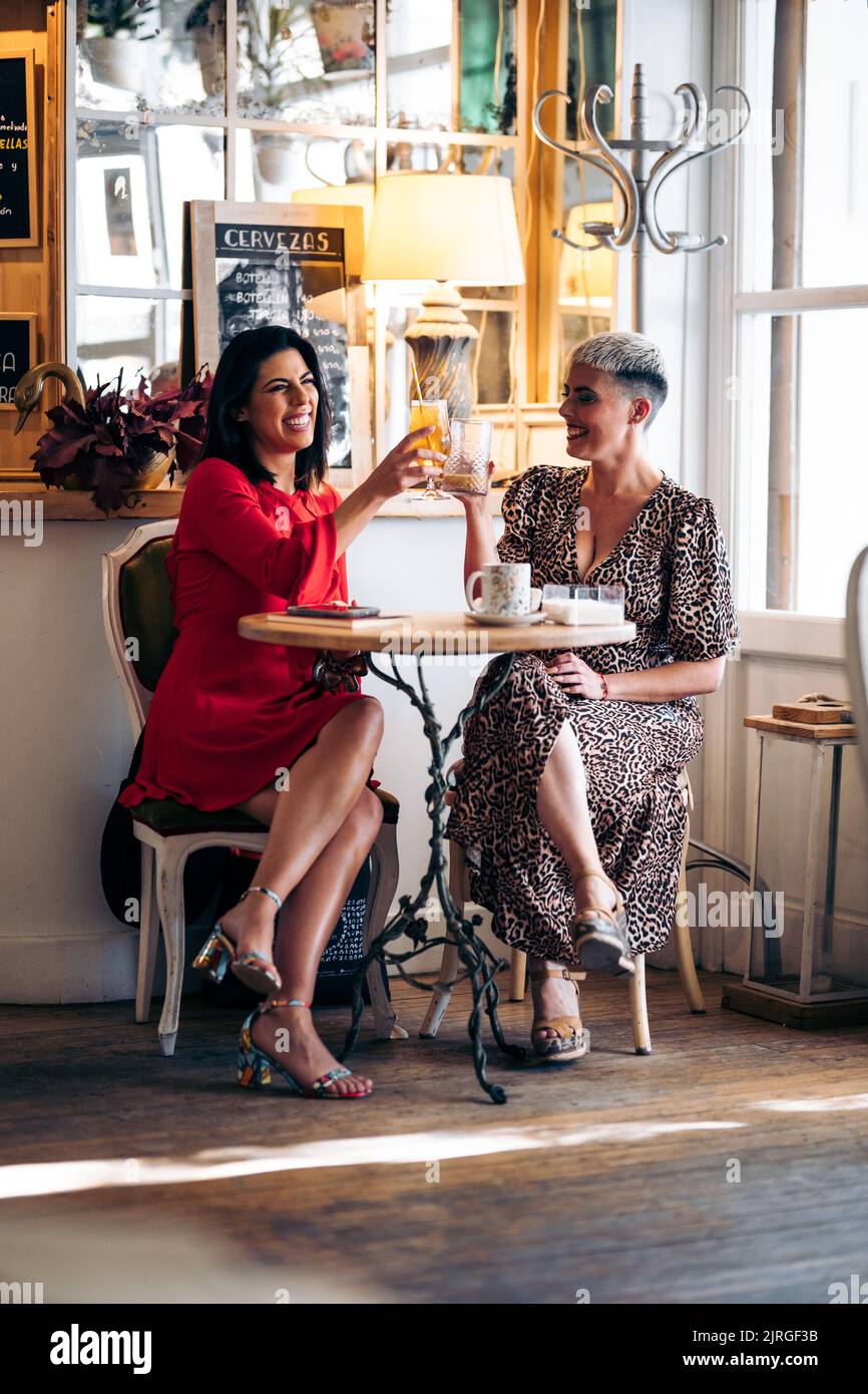 Deux belles femmes toasts dans un bar vintage Banque D'Images