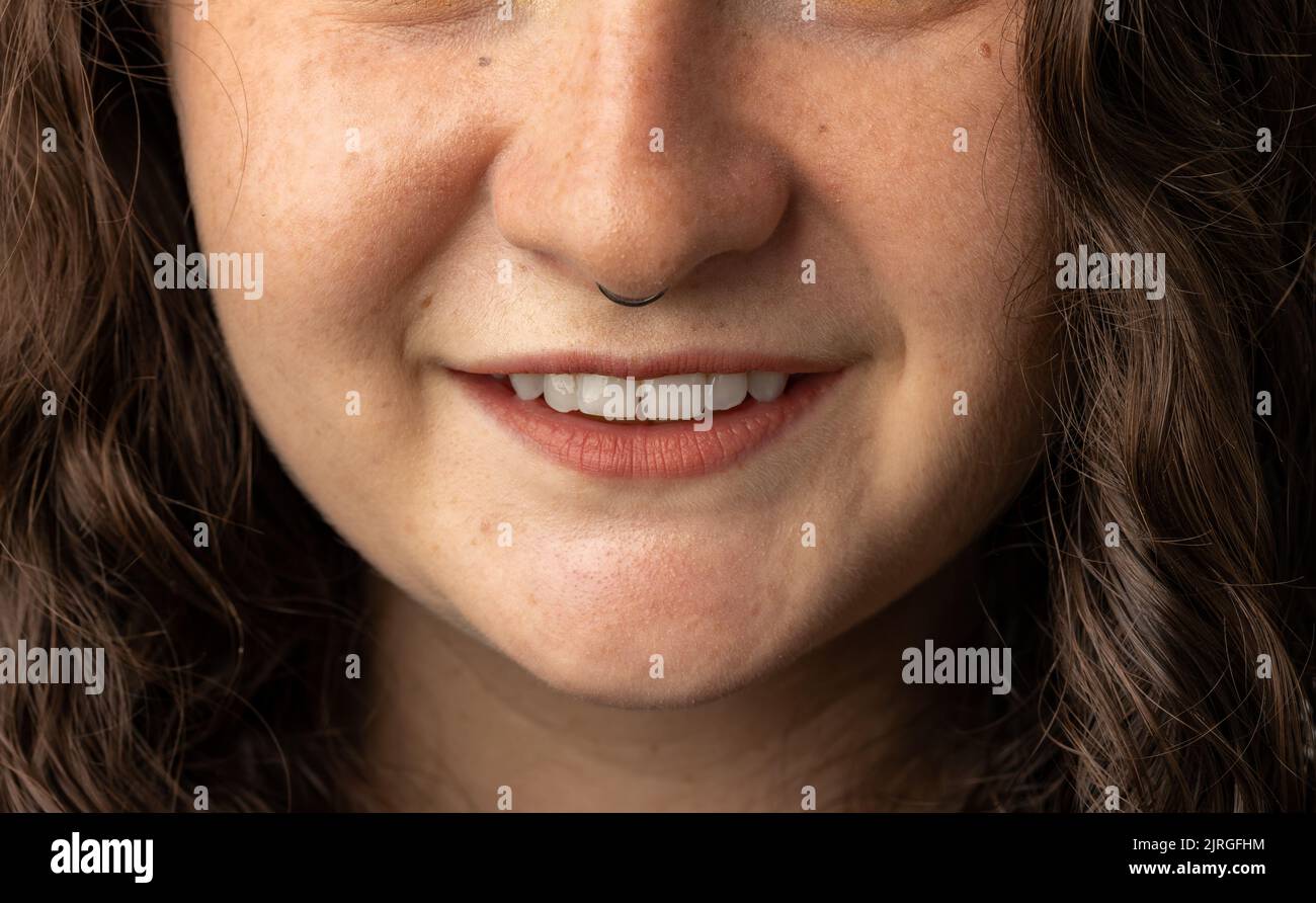 Gros plan de la jeune femme avec le nez percé souriant. Banque D'Images