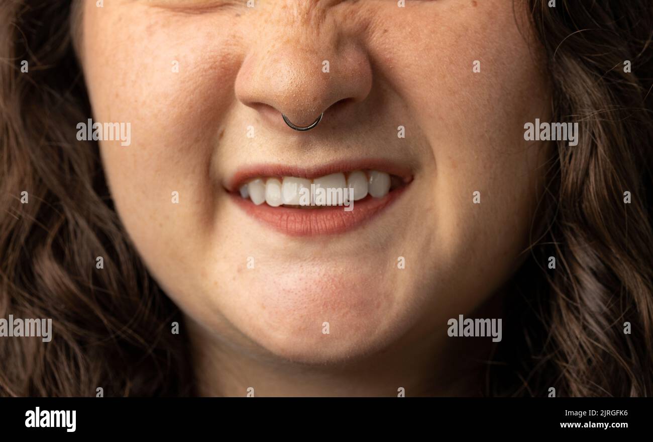 Gros plan d'une belle jeune femme qui se relève le nez, avec anneau de nez Banque D'Images