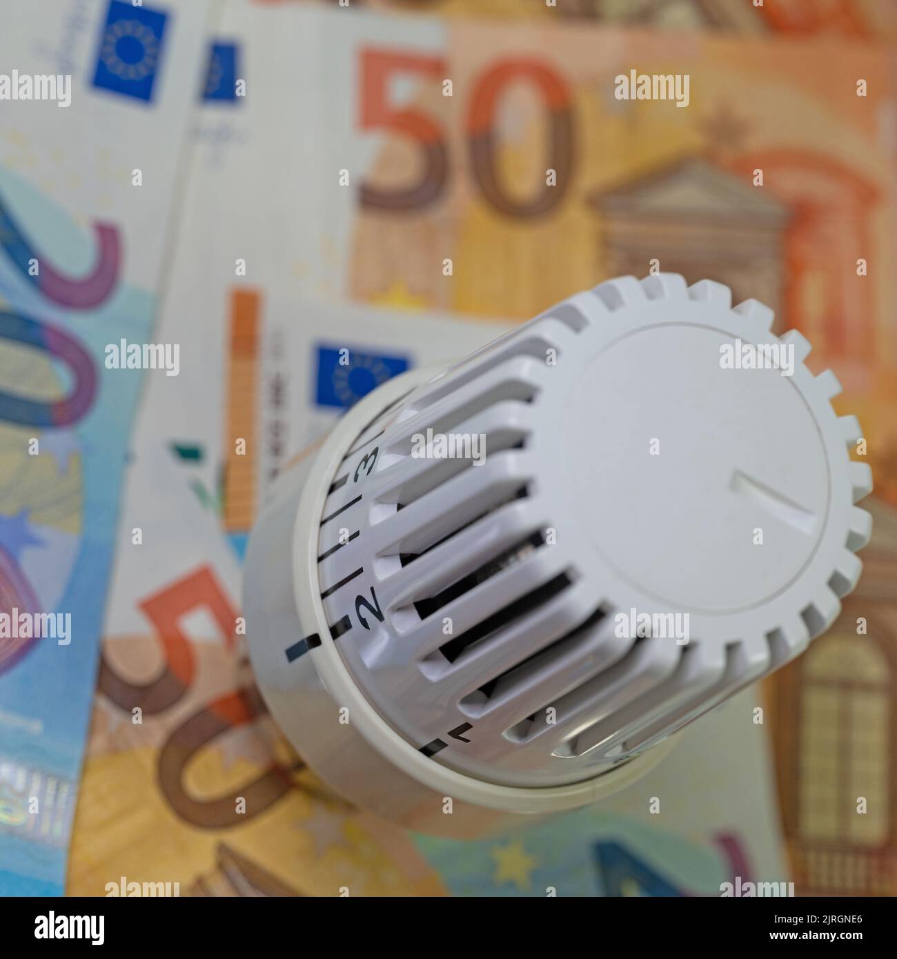 Thermostat devant les billets, symbolique des coûts de chauffage Banque D'Images
