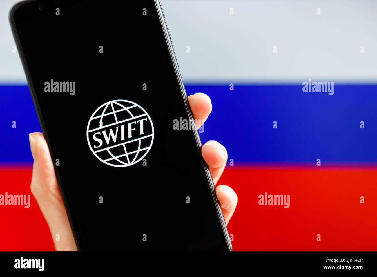 Ukraine, Kiev - février 23 2022 : portable avec logo SWIFT et drapeau russe en arrière-plan. Sanctions contre la Russie, déconnexion du concept SWIFT. Banque D'Images