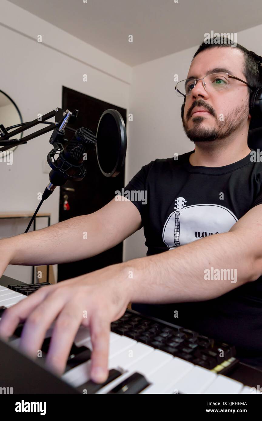 image verticale de l'homme vénézuélien latin caucasien, en cours de piano en ligne à la maison, concept pour les réseaux sociaux et musicaux. Banque D'Images