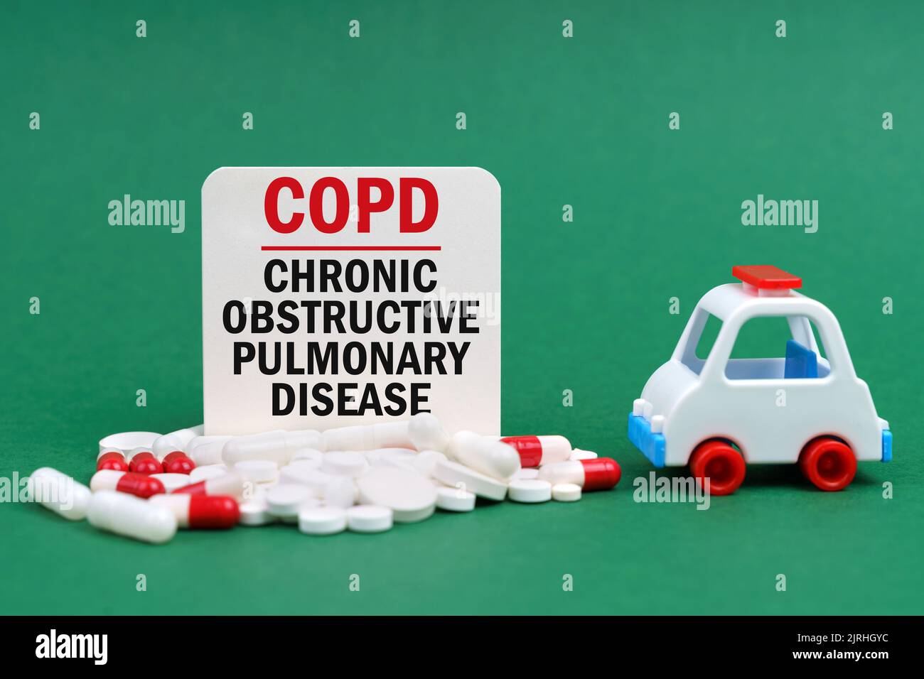 Concept médical. Sur une surface verte, une ambulance, des pilules et un signe blanc avec l'inscription - maladie pulmonaire obstructive chronique Banque D'Images