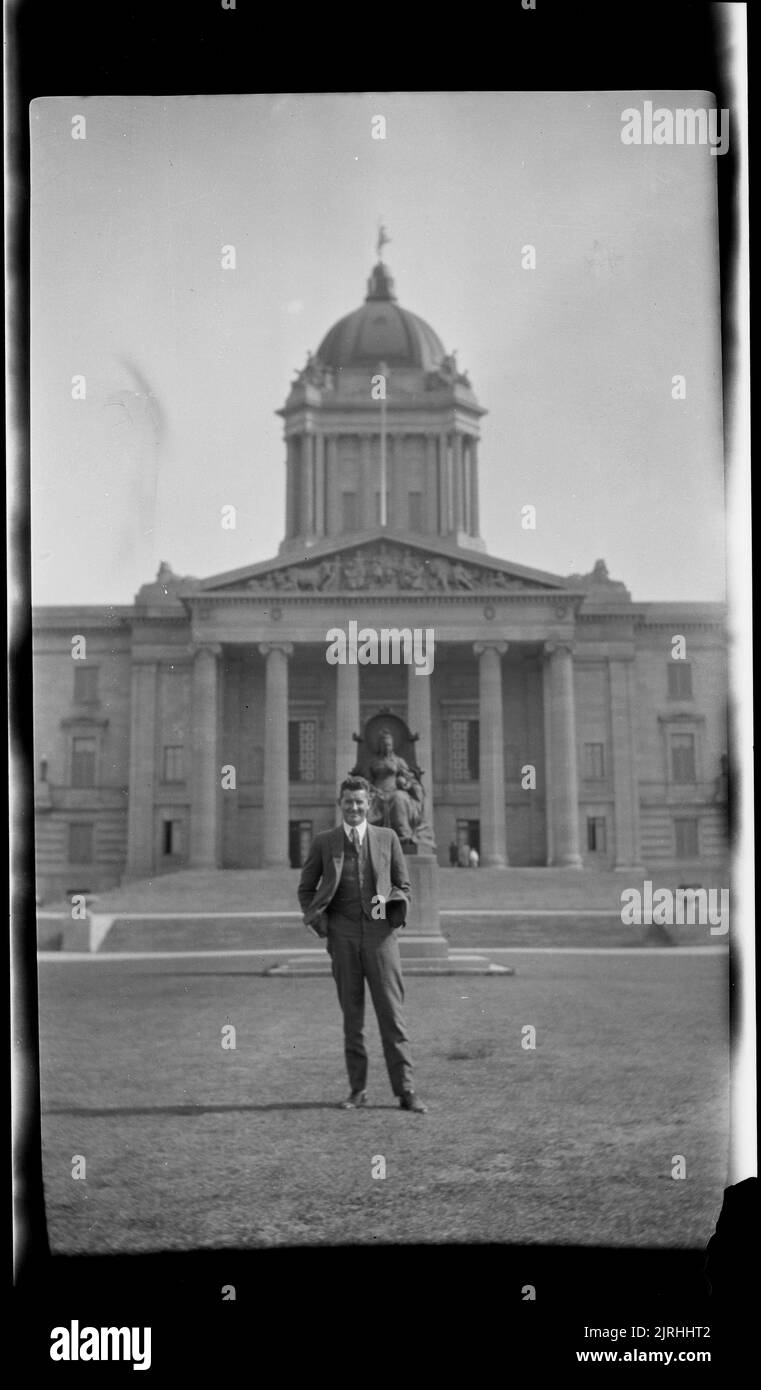 Homme debout devant l'édifice de l'Assemblée législative du Manitoba, Winnipeg, 1920s à 1930s, Manitoba, par Roland Searle. Banque D'Images