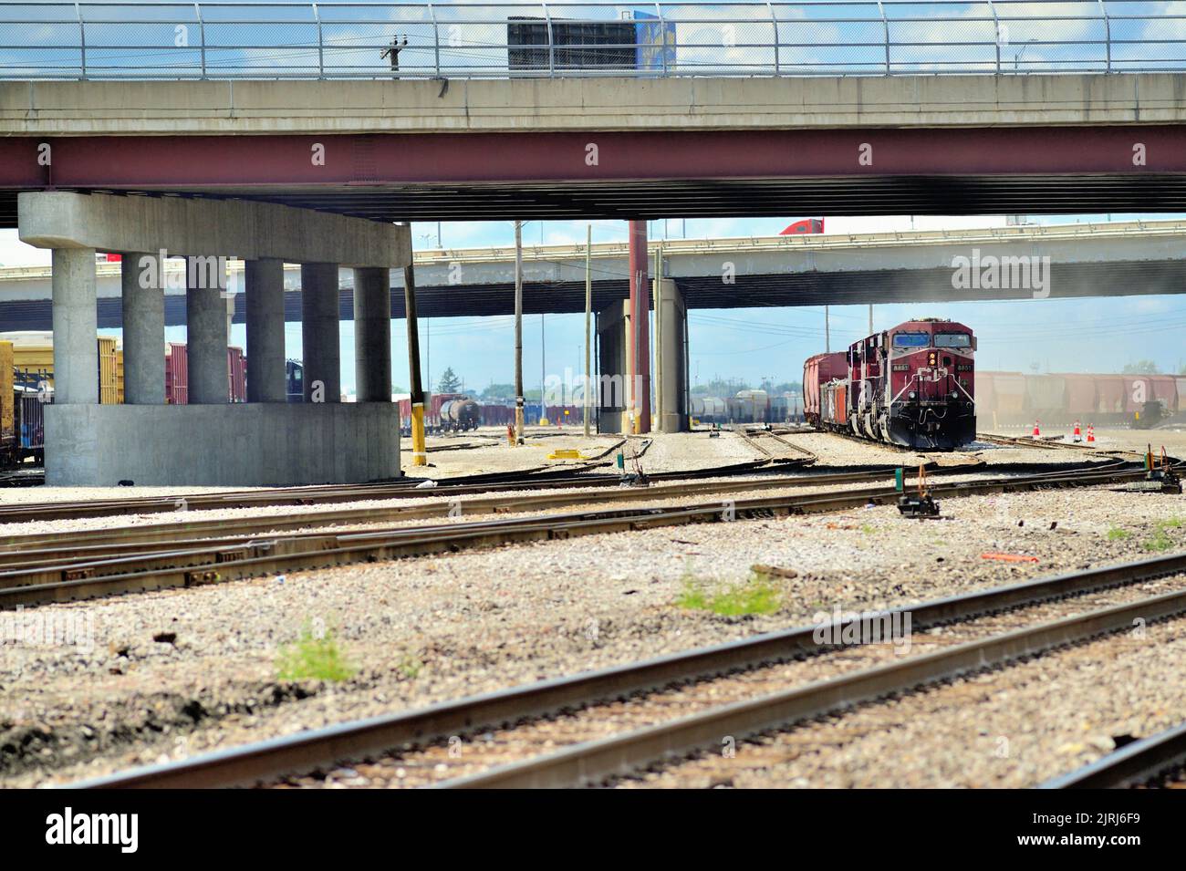 Franklin Park, Illinois, États-Unis. Les locomotives du chemin de fer canadien Pacifique sont placées sous un passage autoroutier menant à un train de marchandises en attente de départ d'une cour. Banque D'Images