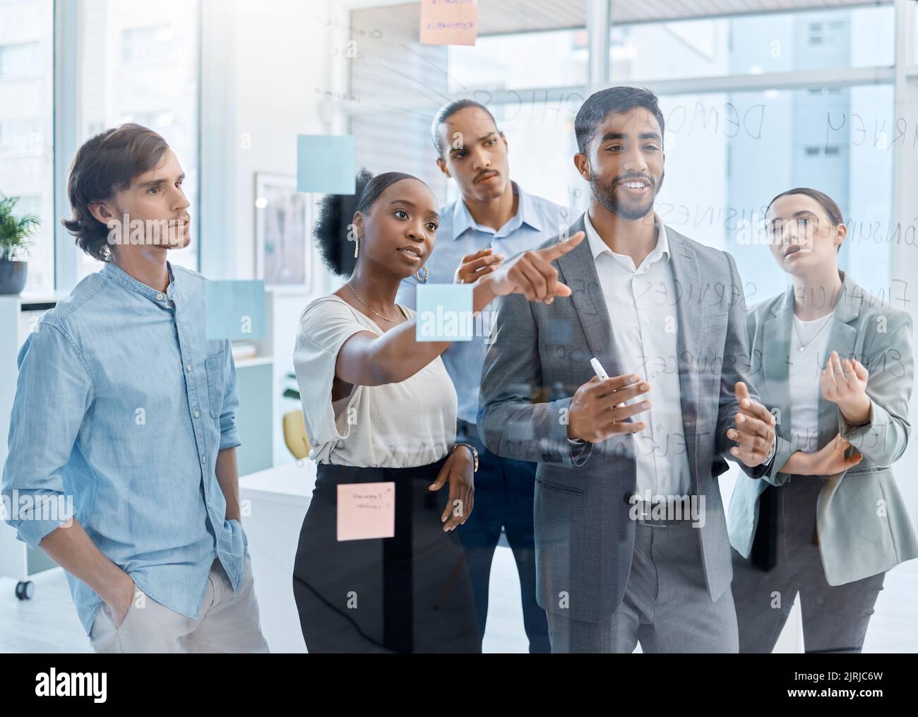 Travail d'équipe, collaboration et planification avec une équipe et son responsable travaillant sur la vision, la mission et la stratégie de leur entreprise. Écriture sur un verre Banque D'Images