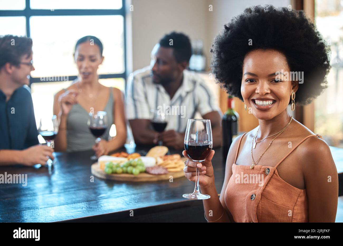 Portrait d'une femme à un événement de fromage et de vin avec des amis divers dans un restaurant moderne. Bonne fille ayant le plaisir et tenant un verre de luxe d'un Banque D'Images