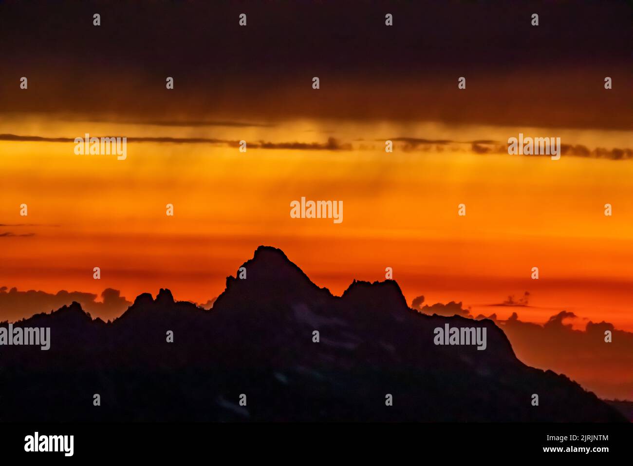 Coucher de soleil fumé au-dessus des montagnes (le plus haut est Del Campo Peak), vue depuis Evergreen Mountain Lookout, Cascade Range, Mt. Les Fores nationales Baker-Snoqualmie Banque D'Images