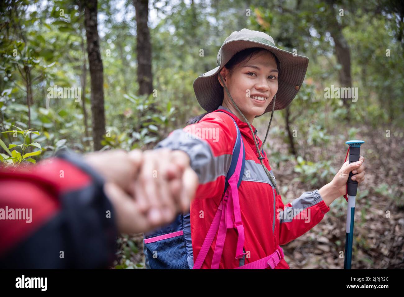 jeune couple en randonnée. jeune homme et femme randonneurs se tenant les mains tout en marchant sur le sentier de montagne. Banque D'Images