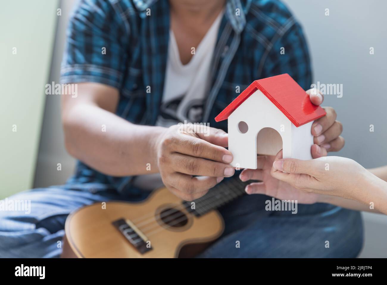 Couple tenant la maison modèle, nouvelle maison en main et achetant la nouvelle maison et se déplaçant ensemble des affaires et le concept immobilier. Banque D'Images