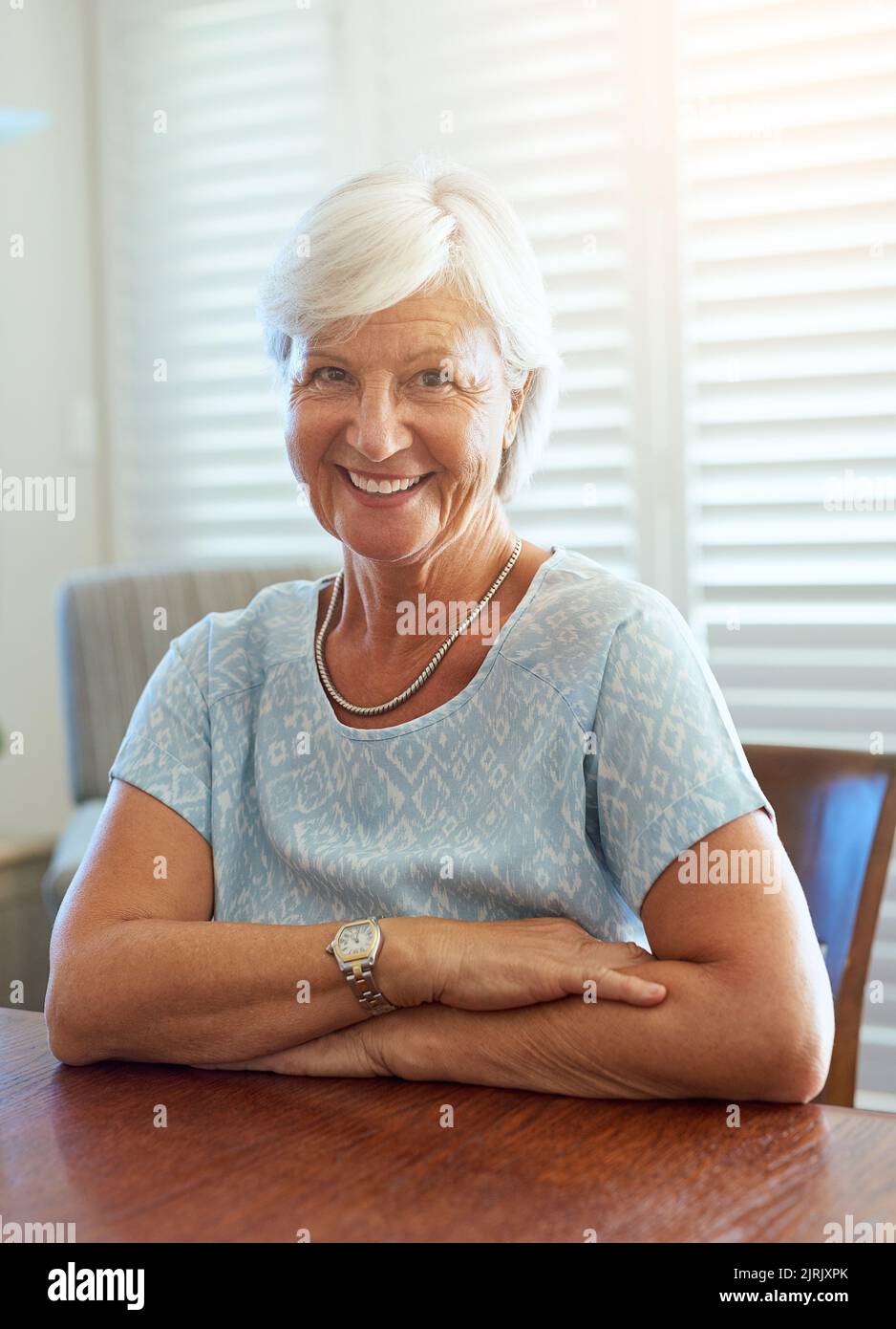 La vieillesse est un cadeau que je suis heureux de recevoir. Portrait d'une femme âgée heureuse assise à une table à la maison. Banque D'Images