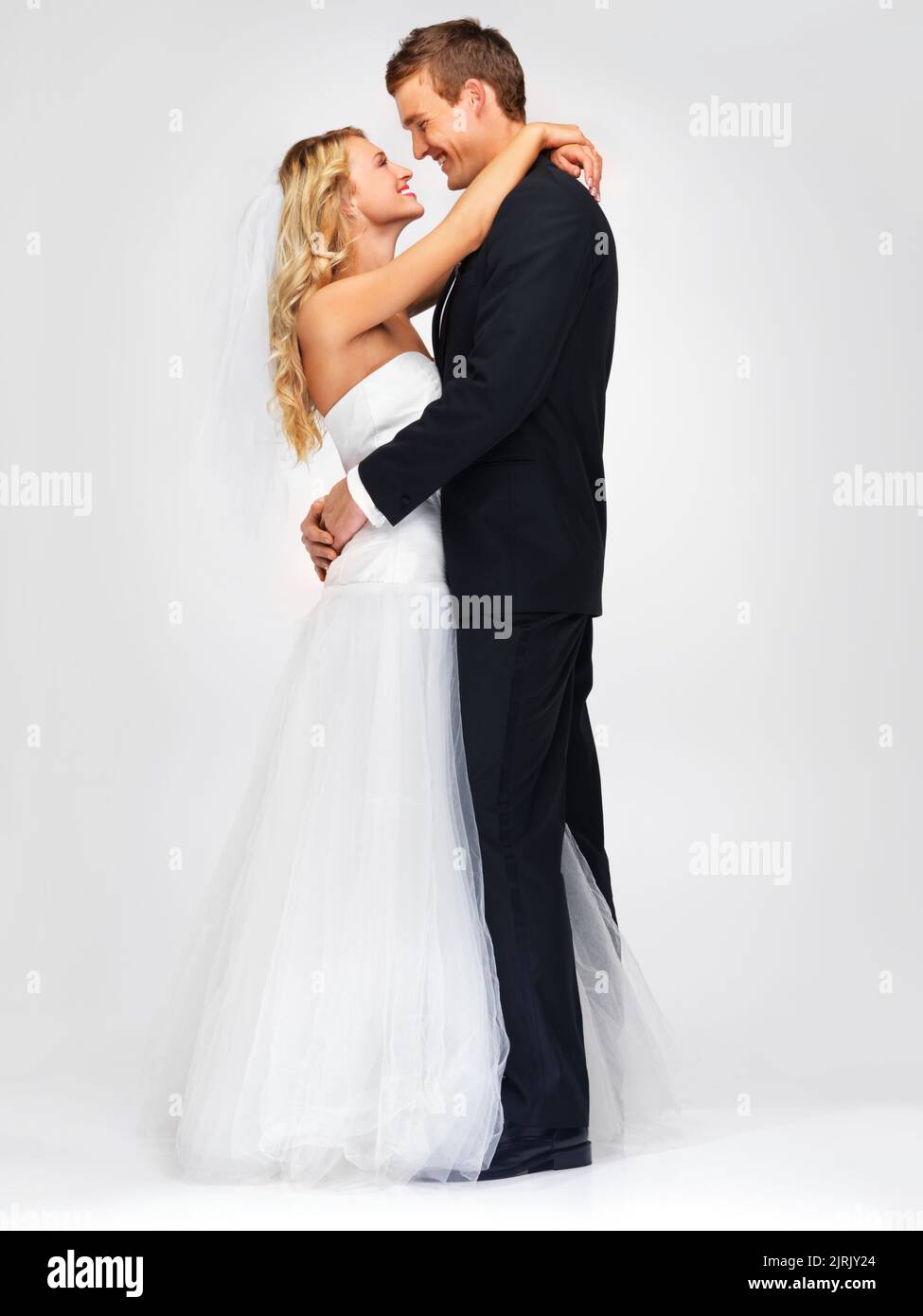 Couple et mariage avec une mariée heureuse et marié en studio sur fond blanc. Habillezvous