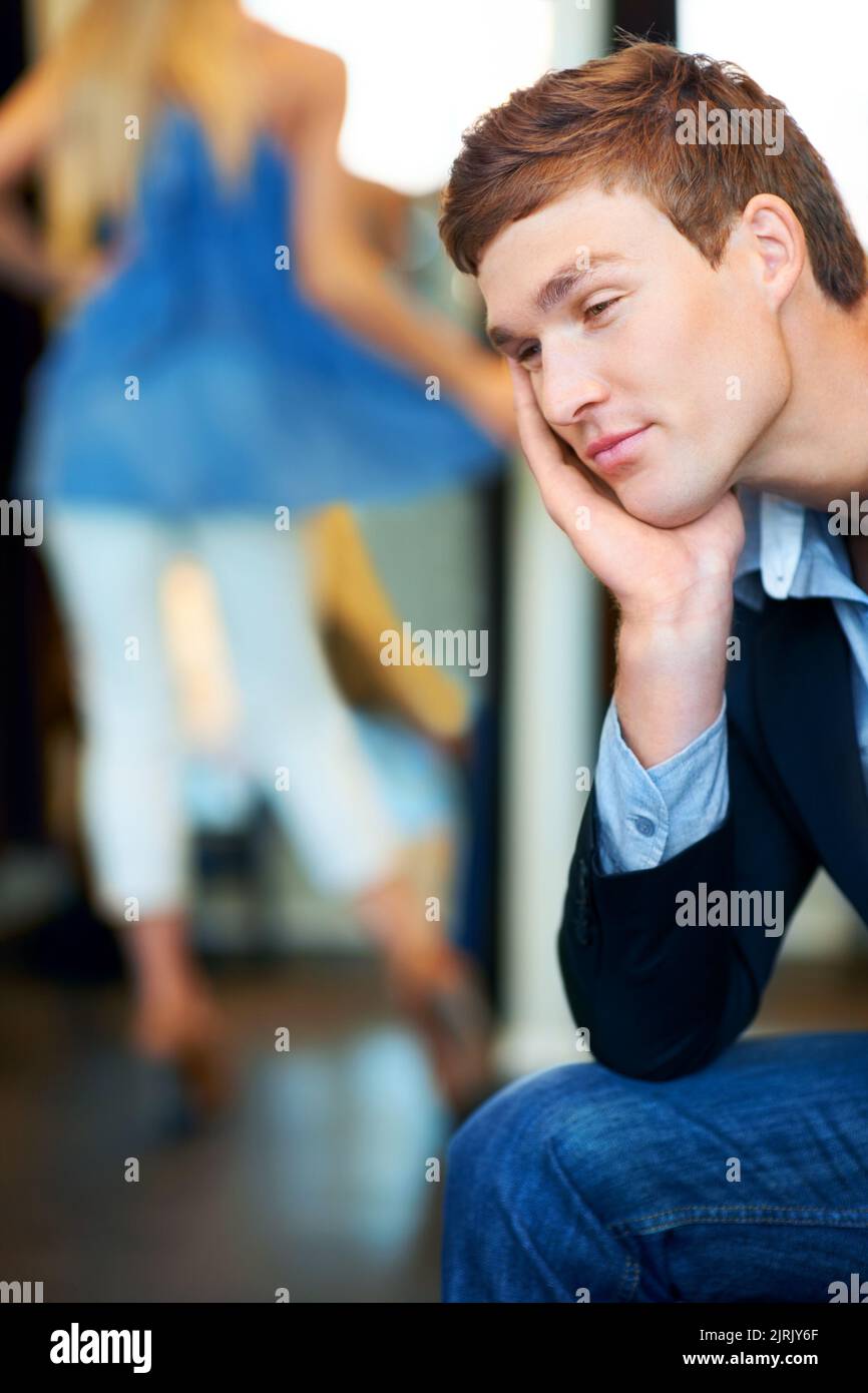 Mode, vente au détail et magasin avec un homme fatigué attendant une femme tout en faisant du shopping dans une boutique de vêtements. Patient dormant presque dans un magasin Banque D'Images