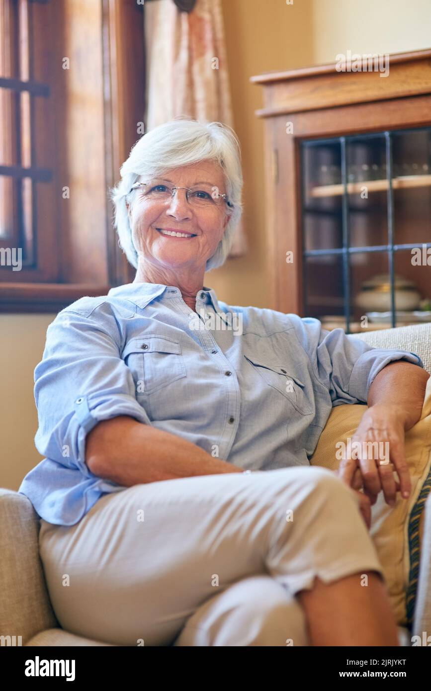 La retraite est aussi relaxante que cela semble. Portrait d'une femme âgée qui se détend sur le canapé à la maison. Banque D'Images